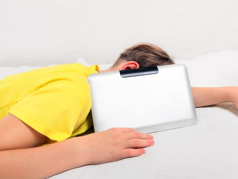 Tired Kid sleep with Tablet Computer on the Bed