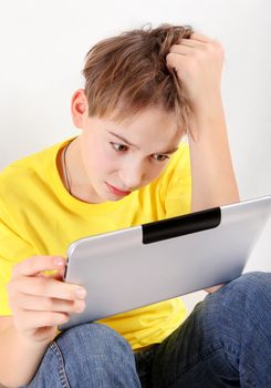 Sad Kid with Tablet Computer on the White Background