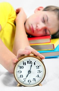 Kid sleep with Alarm Clock on the Bed. Focus on the Clock