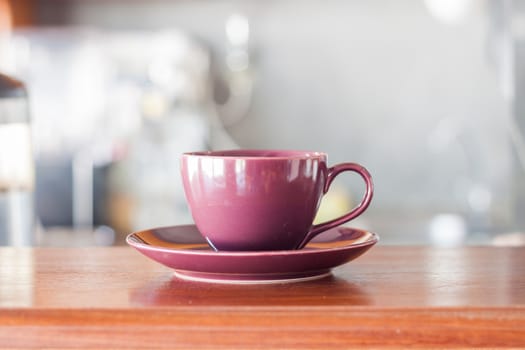 Purple coffee cup in coffee shop, stock photo