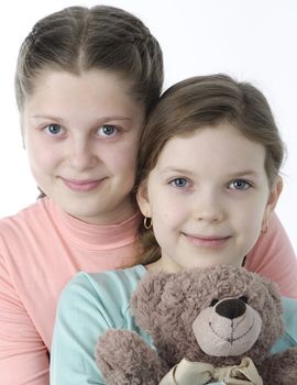 Portrait of pretty little girls holding teddy bear isolated on white
