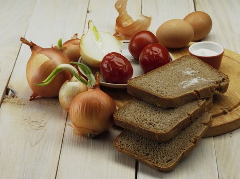 root of onion and bread on wooden board