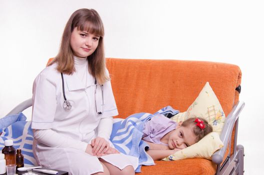 Doctor pediatrician examines a sick child at home