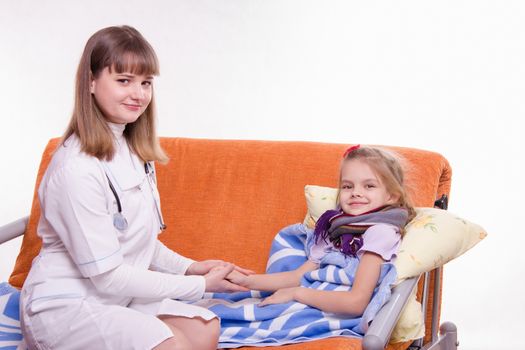 Doctor pediatrician examines a sick child at home