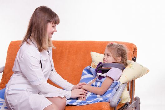 Doctor pediatrician examines a sick child at home
