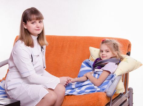 Doctor pediatrician examines a sick child at home