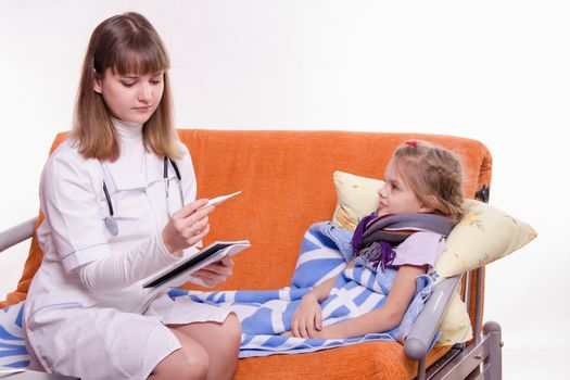 Doctor pediatrician examines a sick child at home