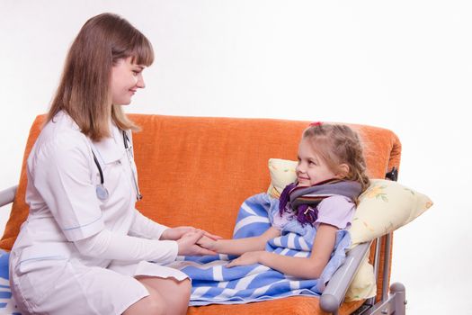 Doctor pediatrician examines a sick child at home
