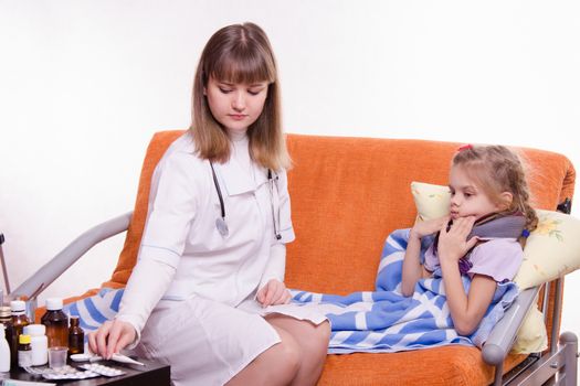 Doctor pediatrician examines a sick child at home