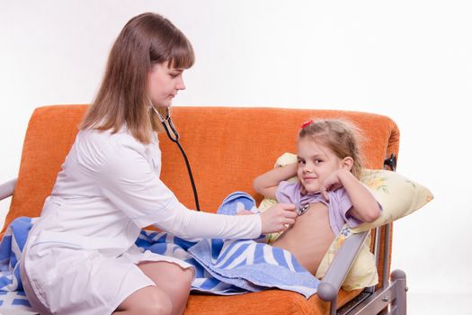 Doctor pediatrician examines a sick child at home