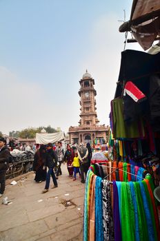 Jodphur, India - January 1, 2015: Unidentified people shopping at market under the clock tower on January 1, 2015 in Jodhpur, India. Jodhpur is known as the blue city.