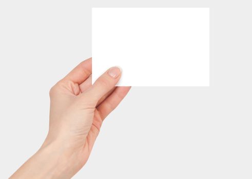 Women's fingers holding a blank white card