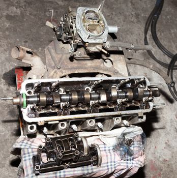 Car engine parts laid out on the floor in the repair shop