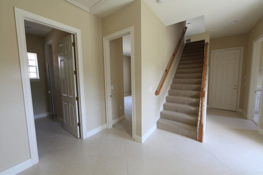 A hallway with stairs and doorways in a home