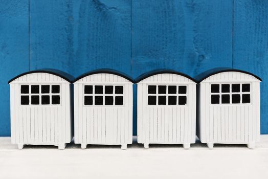 White beach houses in a row against a blue background