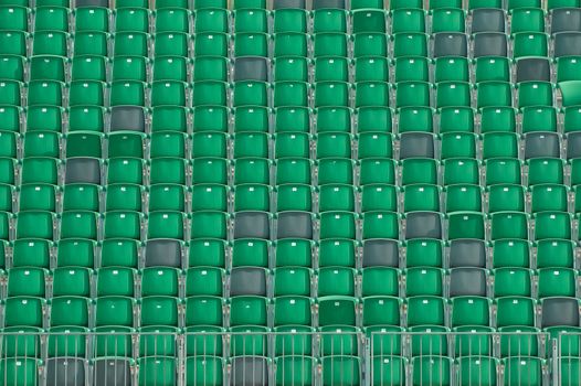 rows of empty plastic grandstand seats in an outdoor sporting venue