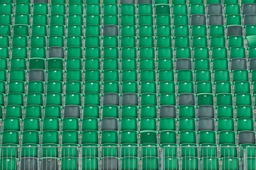 rows of empty plastic grandstand seats in an outdoor sporting venue