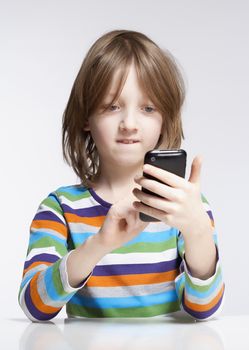 Boy with Blond Hair Reading Text Message on Mobile Phone