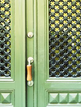 Green door with decorative grid. Entrance to a building in Stockholm, Sweden.