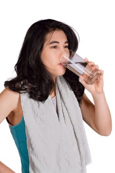 Beautiful biracial teenage girl drinking water while exercising