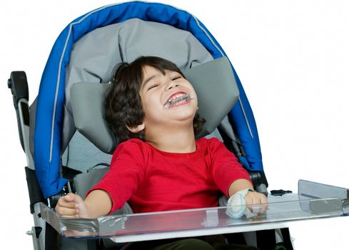 Three year old biracial disabled boy in medical stroller, happy and smiling