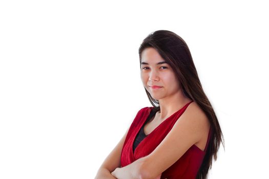 Beautiful biracial teen girl in red dress standing arms crossed, smiling. Challenging expression