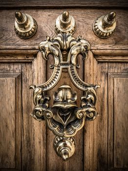 A Grand Ornate Brass Door Knocker On A Heavy Wooden Door In Spain