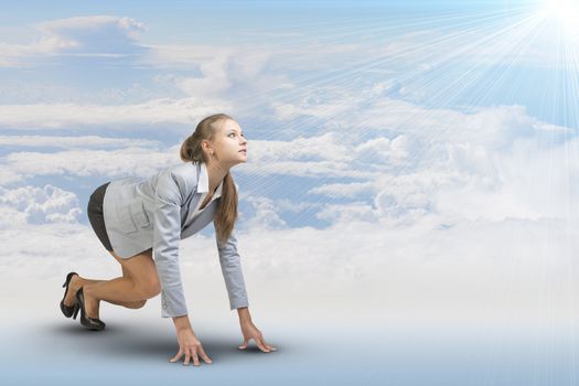 Businesswoman standing in running start pose, looking at light shining ahead. Sky and clouds as backdrop