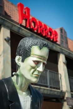 Frankenstein monster mannequin with horror sign above its head