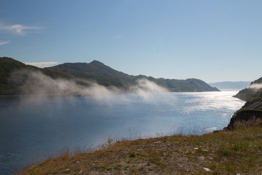Picture of a fjord with some clouds in the midle