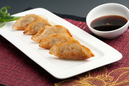 Fried thai gyoza dumpling appetizers with soy dipping sauce.