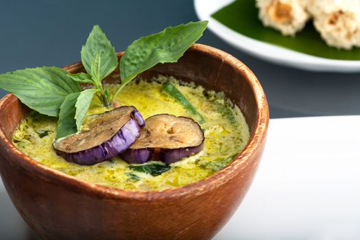 A dish of fresh Thai green curry soup with pancakes and appetizers.