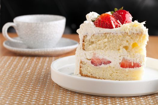 Slice of strawberry shortcake with white chocolate shavings.