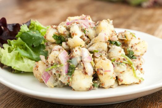 Potato salad freshly homemade without mayonaise.  Ingredients include cilantro olive oil vinegar whole grain dijon mustard red onions and potatoes. 