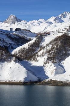 View of Tignes village in winter with lake, France.
