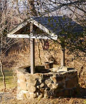 Old stone country well with wooden roof