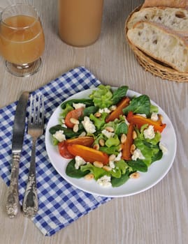 Fresh salad mix with persimmons, feta cheese and peanuts