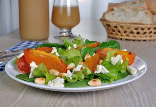 Fresh salad mix with persimmons, feta cheese and peanuts