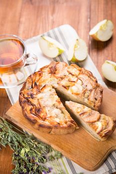 apple pie, with an intagliated piece and cup of tea