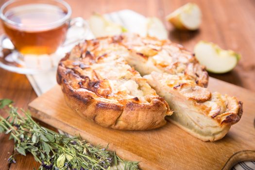 apple pie, with an intagliated piece and cup of tea