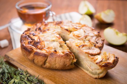 apple pie, with an intagliated piece and cup of tea