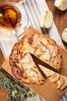 apple pie, with an intagliated piece and cup of tea