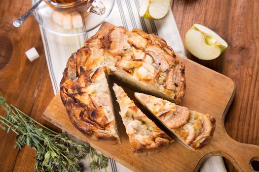 apple pie, with an intagliated piece and cup of tea