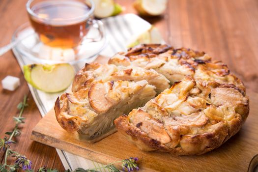 apple pie, with an intagliated piece and cup of tea