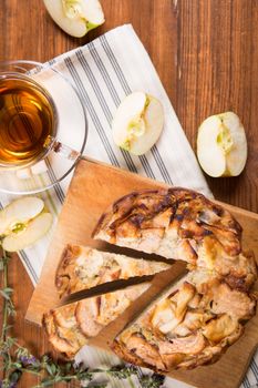 apple pie, with an cut piece and cup of tea