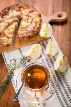 apple pie, with an cut piece and cup of tea
