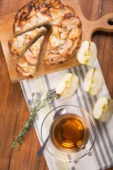 apple pie, with an cut piece and cup of tea