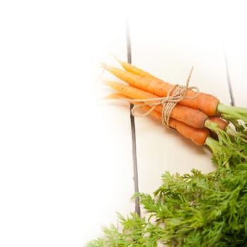 fresh baby carrots bunch tied with rope on a rustic table