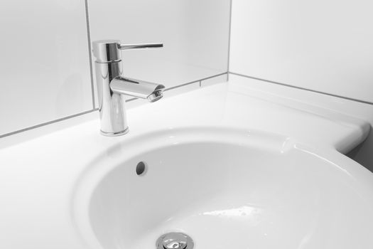 Faucet and white basin in a hotel bathroom