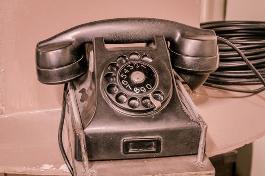 old rotary telephone on wood table, with Vintage background